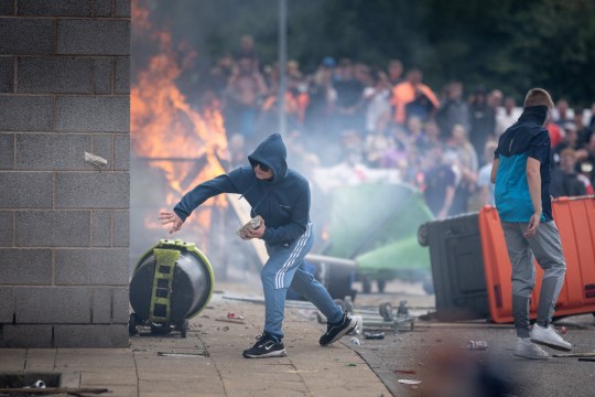 Riot police officers push back anti-migration protesters outside the Holiday Inn Express Hotel which is housing asylum seekers on August 4, 2024 in Rotherham, United Kingdom