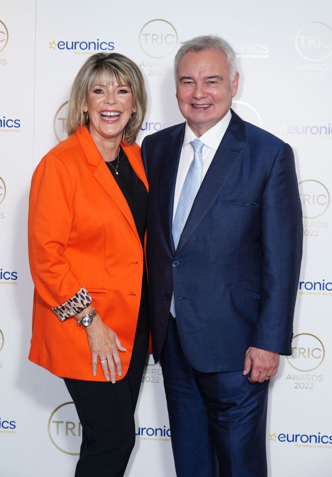 a man and woman are posing for a picture in front of a wall that says euronics